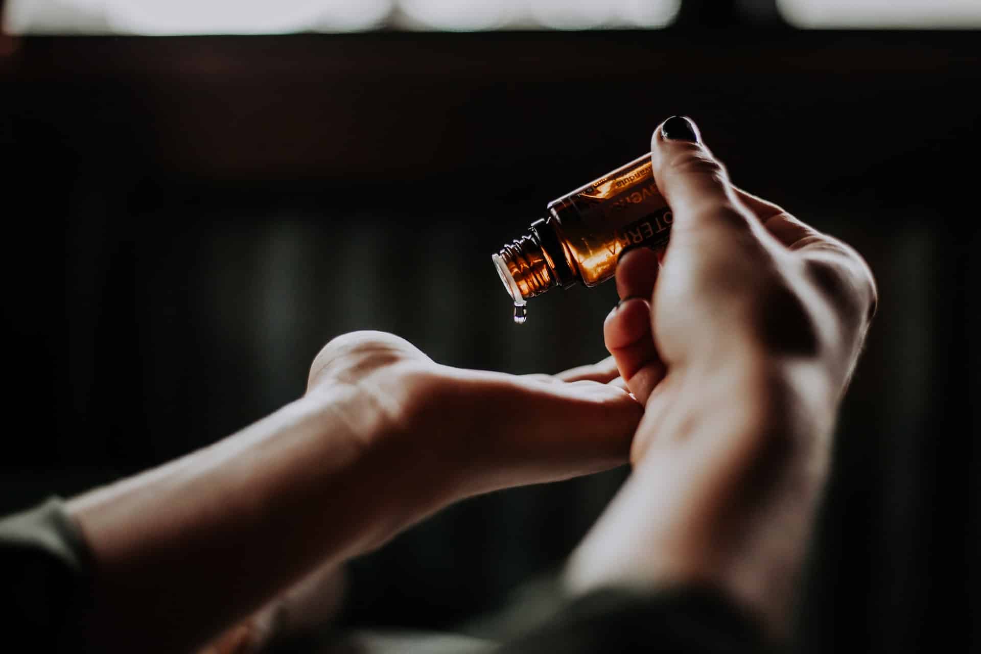 Essential oil being dripped on a palm of a hand