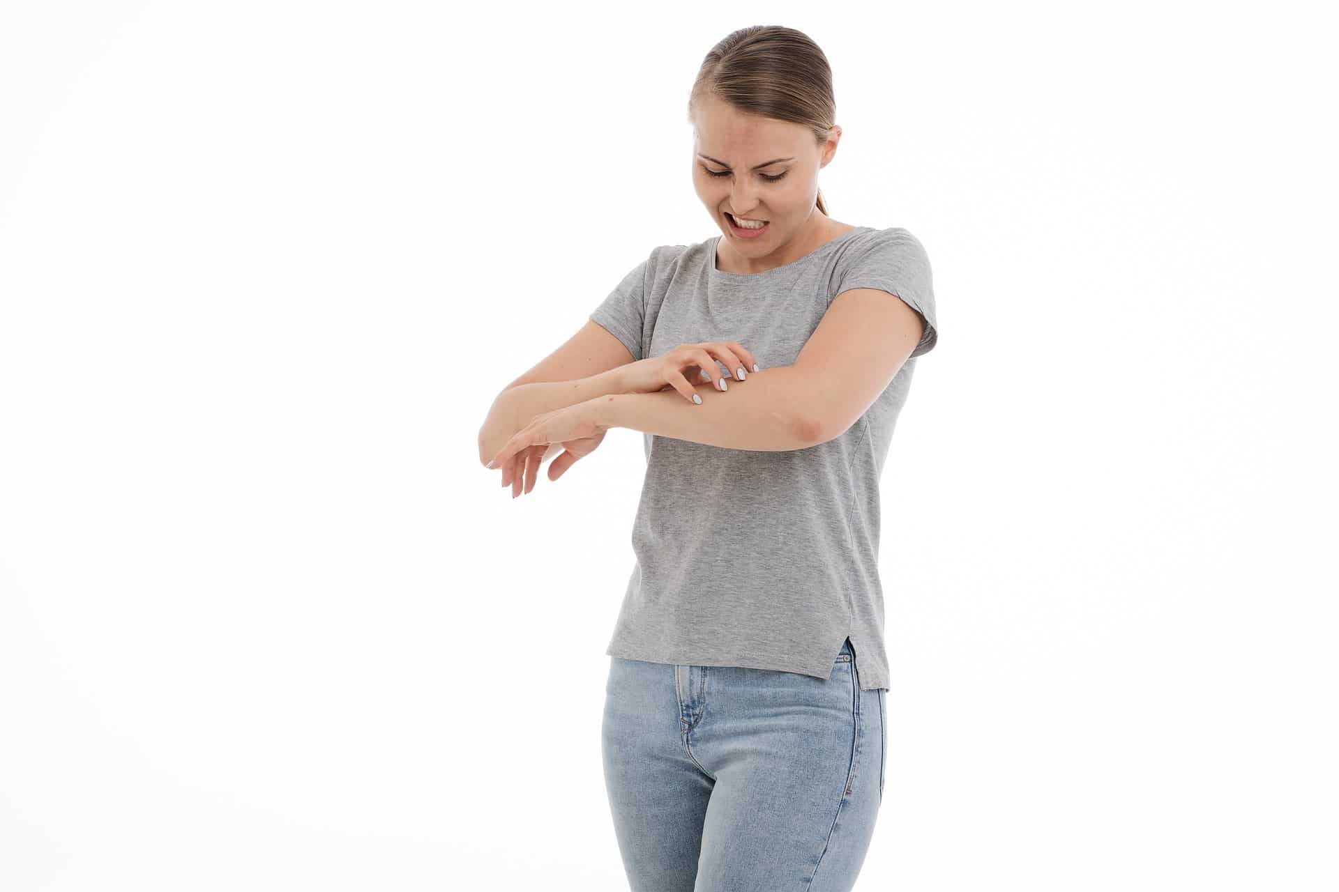A woman scratching her left forearm